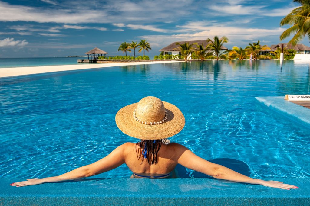 Woman with hat at beach pool in Maldives